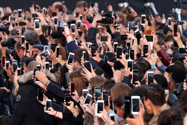 People use their smartphone to take photos of the L'Oreal fashion show on the Champs Elysees avenue during a public event organized by French cosmetics group L'Oreal as part of Paris Fashion Week, France, October 1, 2017.  REUTERS/Charles Platiau     TPX IMAGES OF THE DAY - RC1CAB6813E0