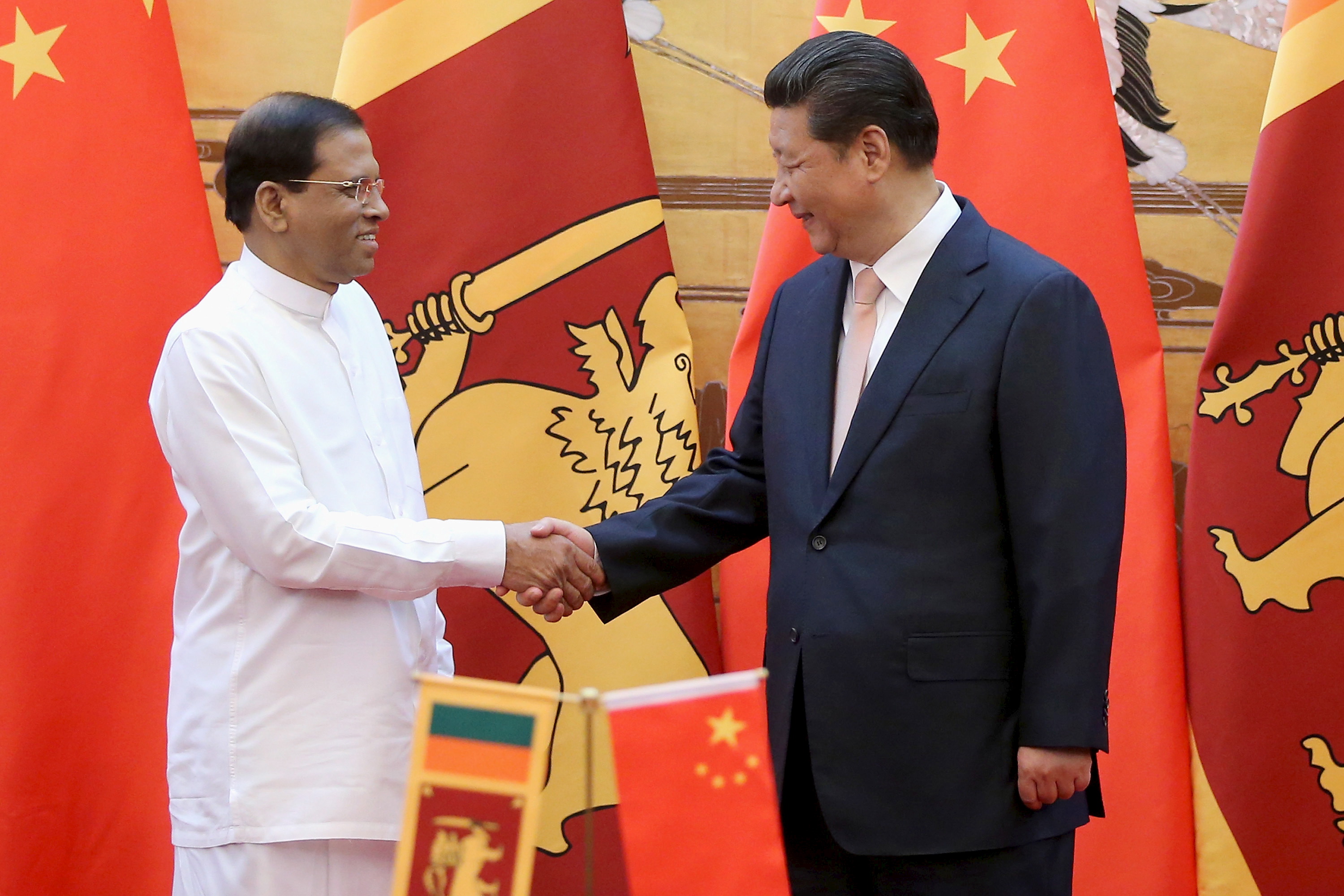 Sri Lankan President Maithripala Sirisena (Left) shakes hands with Chinese President Xi Jinping (Right) during a signing ceremony in the Great Hall of the People on March 26, 2015 in Beijing, China.  REUTERS/Feng Li-Poo/Pool - RTR4UWHZ