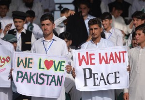 Pakistani spectators carry placards during a T20 cricket match between Pakistan XI and UK Media XI at the Younis Khan Cricket Stadium in Miranshah, the former stronghold of Al-Qaeda and Taliban militants, in North Waziristan near the Afghan border on September 21, 2017. / AFP PHOTO / AAMIR QURESHI